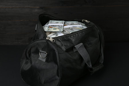 Dollar banknotes in bag on black tableの写真素材