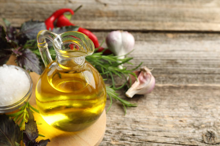 Cooking oil in jug on wooden table, closeup. Space for textの写真素材