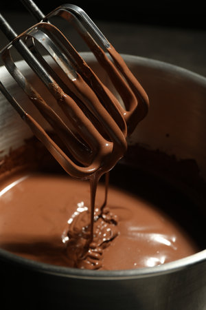 Chocolate dough dripping from mixer into bowl, closeupの写真素材