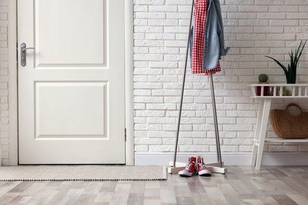 Metal rack with clothes and sneakers in hallwayの写真素材
