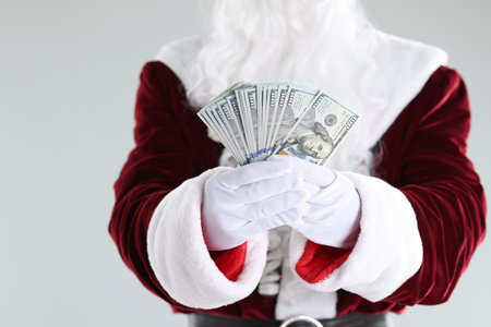 Santa Claus holding dollar banknotes on gray background, closeupの写真素材