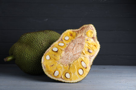 Delicious cut and whole exotic jackfruit on gray wooden tableの写真素材