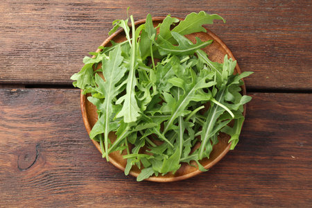 Fresh green arugula leaves on wooden table, top viewの写真素材