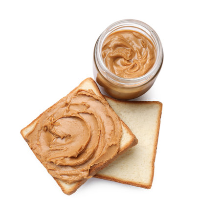 Peanut butter in jar and pieces of bread isolated on white, top viewの写真素材