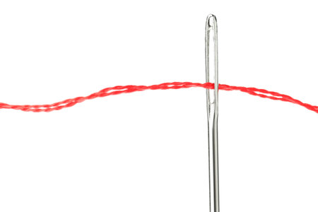 Sewing needle with red thread isolated on white, closeup