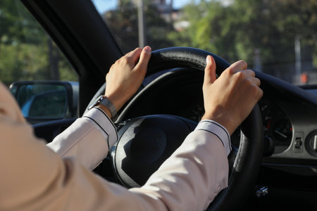 Woman holding steering wheel while driving car, closeupの写真素材