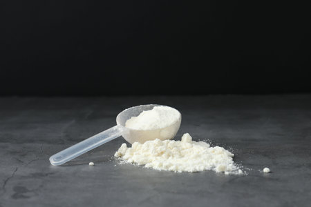 Protein powder and scoop on gray textured tableの写真素材