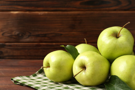 Fresh green apples on wooden table, space for textの写真素材