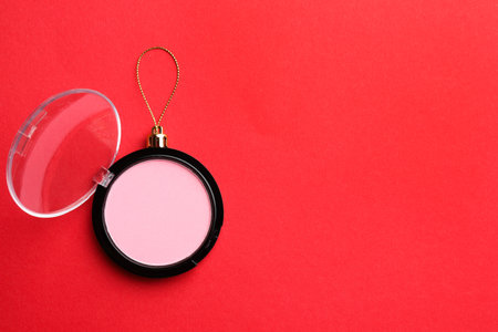 Blusher in shape of Christmas ball on red background, top view. Space for textの写真素材