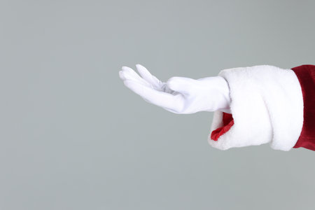 Santa Claus holding something on gray background, closeup. Space for textの写真素材