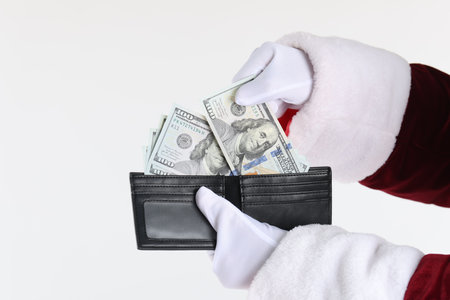 Santa Claus taking dollar banknotes out of wallet on white background, closeupの写真素材
