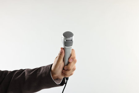 Man with microphone on light background, closeupの写真素材