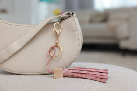 Stylish bag with pink leather keychain on soft surface indoors, closeupの写真素材