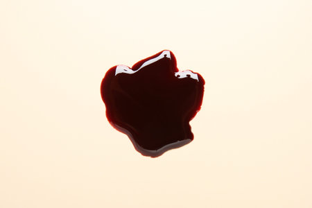 Stain of blood on beige background, top viewの写真素材