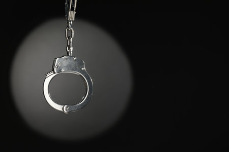 Metal chain handcuffs on dark background. Space for textの写真素材