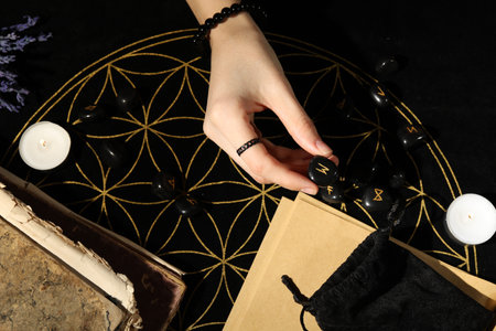 Woman with black runes at divination mat, top viewの写真素材