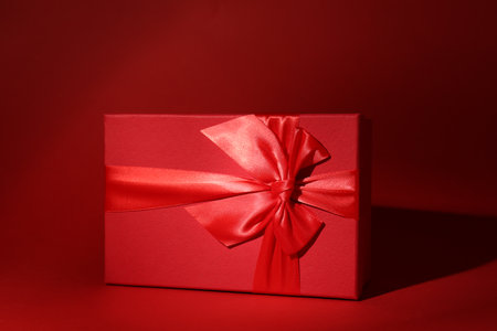 Red gift box on dark red backgroundの写真素材