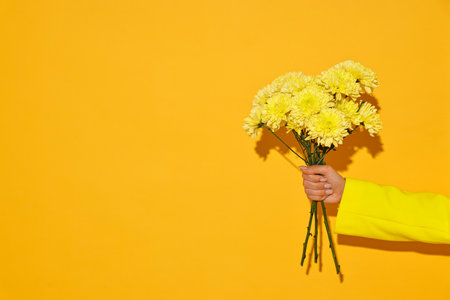 Woman with beautiful bouquet of flowers on yellow background, closeup. Space for textの写真素材