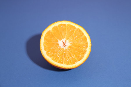 Half of orange on blue background. Citrus fruitの写真素材