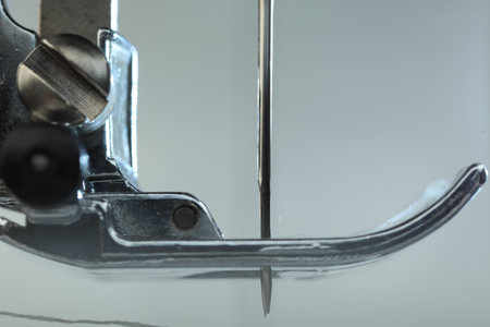 Sewing machine on light gray background, macro view