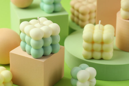 Beautiful bubble candles and geometric figures on green background, closeupの写真素材