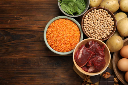 Different products rich in iron on wooden table, flat lay. Space for textの写真素材