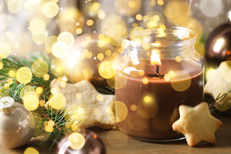 Christmas composition with burning candle on wooden table, bokeh effect. Festive cardの写真素材