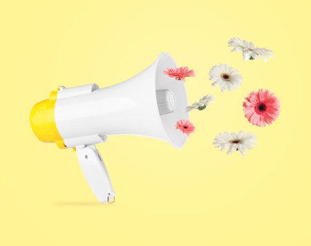 Gerbera flowers flying out of loudspeaker on yellow backgroundの写真素材