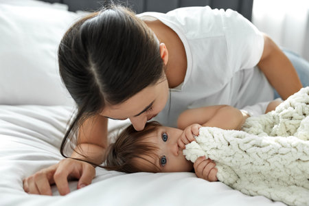 Tender moment between parent and baby on bed