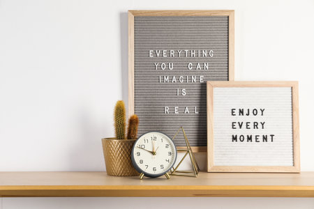 Letter boards with phrases Everything You Can Imagine Is Real, Enjoy Every moment and decor elements on wooden tableの写真素材