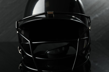Black baseball helmet on dark gray background, closeup