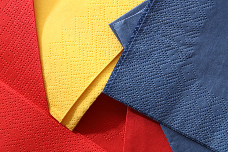 Red, yellow and blue tissues as background, top view