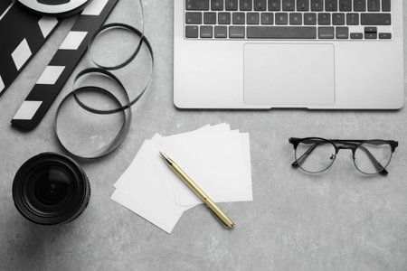 Flat lay composition with camera lens and laptop on gray textured tableの写真素材