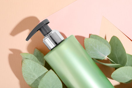 Shampoo in bottle and green eucalyptus leaves on color background, top viewの写真素材