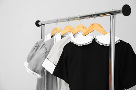Maids' uniforms on clothing rack against gray background, closeupの写真素材