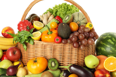 Many different fruits and vegetables in wicker basket isolated on whiteの写真素材