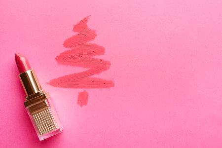 Christmas tree drawn with lipstick on pink background, top view. Space for textの写真素材