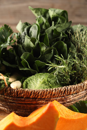 Different fresh herbs and pumpkin on wooden table, closeupの写真素材