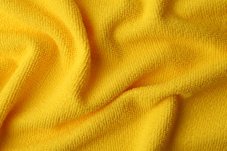 Clean yellow microfiber cloth as background, top viewの写真素材