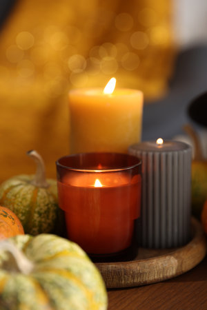 Burning candles and pumpkins on wooden table indoors, closeup. Halloween celebrationの写真素材