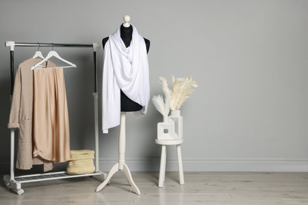 Female mannequin with white scarf and other clothes indoorsの写真素材
