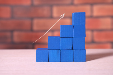 Stair of blue cubes and arrow on pink table. Step-by-step conceptの写真素材