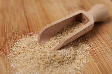 Oat bran in scoop on wooden table, closeupの写真素材
