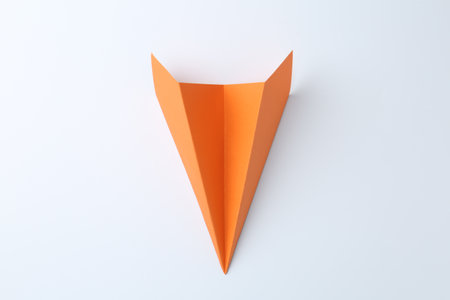 One handmade orange paper plane on white background, top viewの写真素材