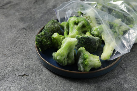 Frozen broccoli out of plastic bag on gray table, closeupの写真素材