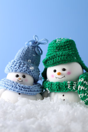 Cute decorative snowmen against light blue background, closeupの写真素材