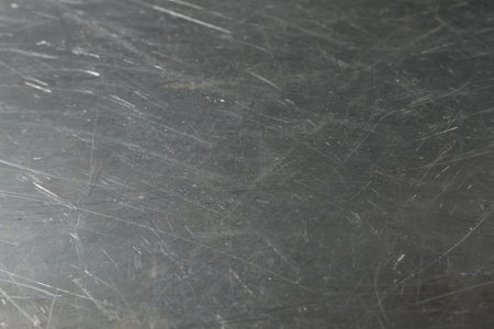 Texture of scratched metallic surface as background, closeup