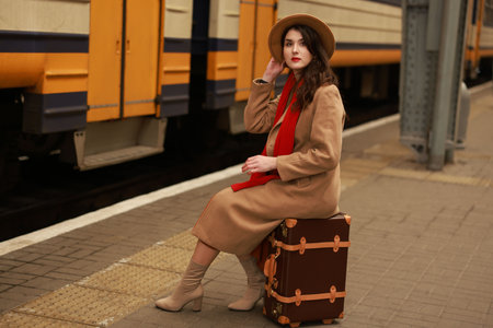 Woman with suitcase on platform of railway stationの写真素材