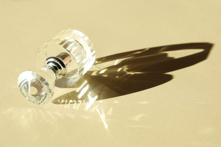 One perfume bottle casting beautiful shadow on beige background, closeup. Space for text
