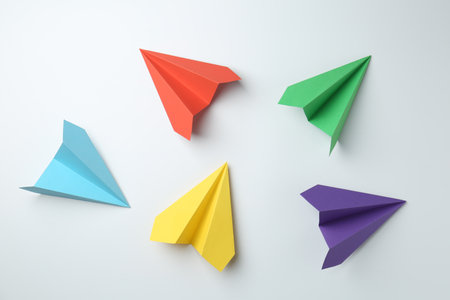 Handmade color paper planes on white background, flat layの写真素材